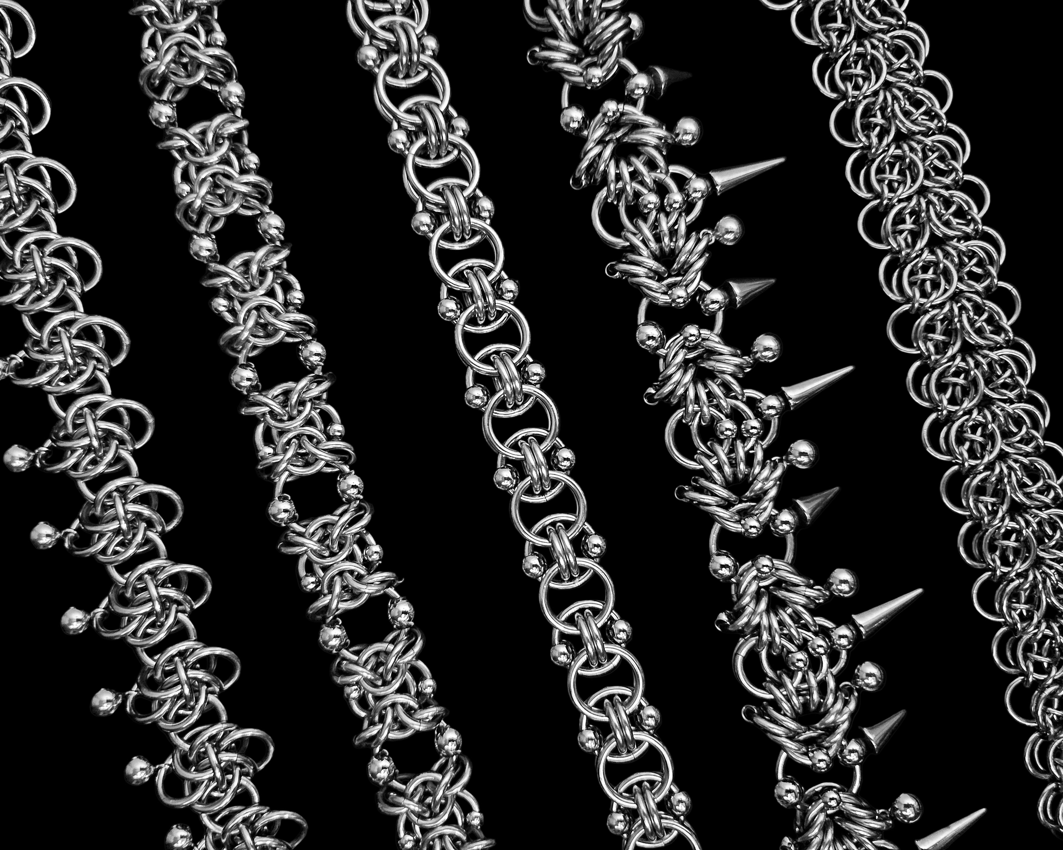 Silver chain necklaces with varying designs on a black background